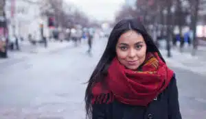 Portrait of a beautiful brunette Asian girl appearance in a red scarf on the street in Canada