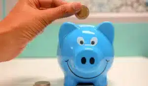 Dropping a coin in a cute piggy-bank