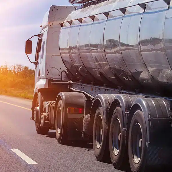 Big rig truck rolling down the highway into the sunset hauling fuel