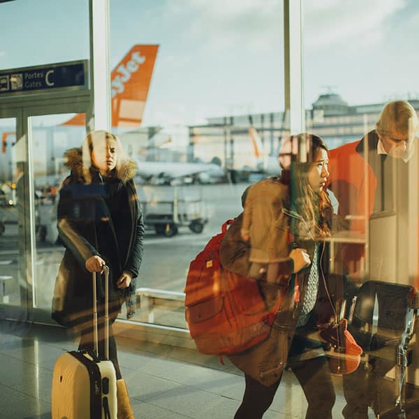 A group of people travelling and walking through an airport bridge