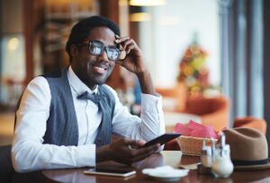 Elegant young businessman with smartphones sitting in a cafe