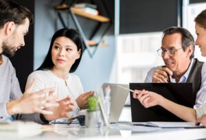 A diverse group of business people gathered around a table discussing an idea