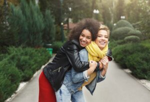 Two women in a park hugging and having a great time