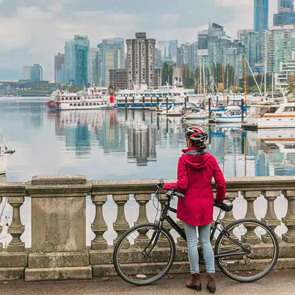 A woman overlooking a Vancouver bridge with her bike