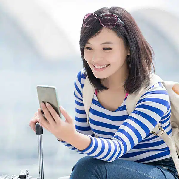 Attractive woman looking at her phone being repatriated