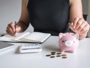 Woman sitting at a desk, doing a budget and saving her pennies