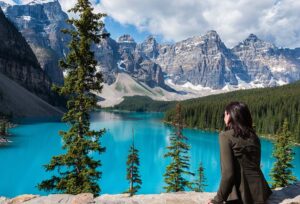 Woman relocating to Canada sitting at Moraine Lake in Banff National Park, Alberta, Canada