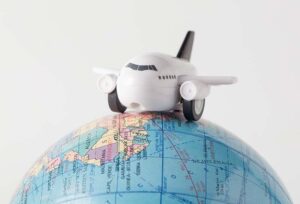 Global Mobility : A small toy airplane sitting on a globe
