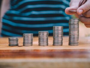 A person stacking coins to represent inflation