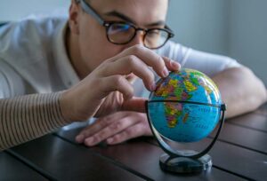 Man with world globe considering an international work assignment