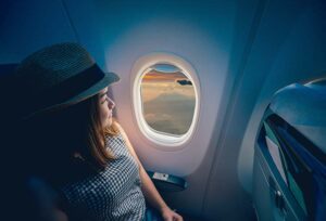 Young traveler looking out an airplane window