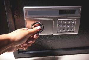 Woman's hand opening a safe full of high value goods