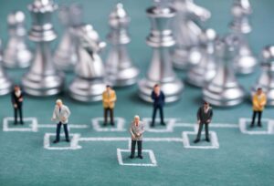 Tiny men figurines on a chess board