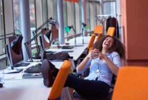 A woman who has relocated and is happy in her new job and her new office - having a good laugh