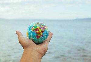 Small globe in someone's hand being held over water