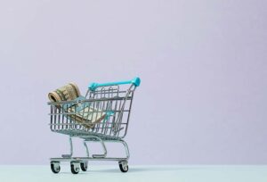Tiny shopping cart with a wad of money in it