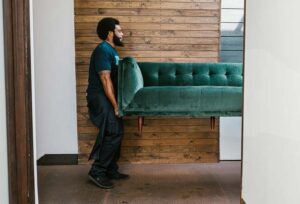 Man moving a green sofa