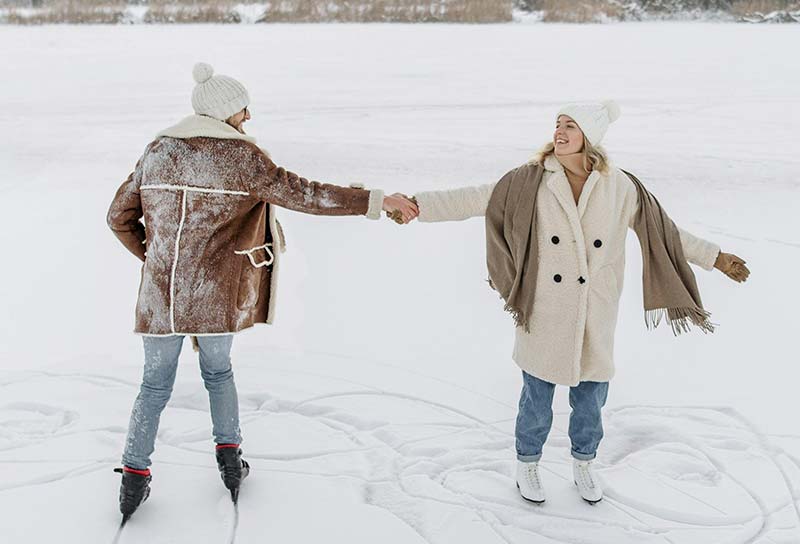 A couple ice skating on a frozen lake in Quebec