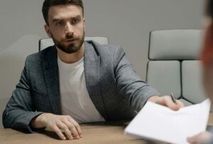 Executive man passing a piece of paper across a desk